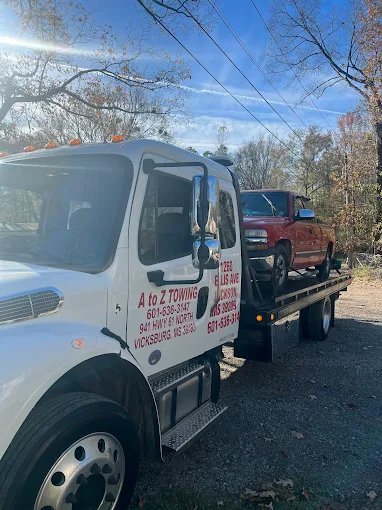 A to Z Towing flatbed tow truck loaded with a customer vehicle in Vicksburg, MS